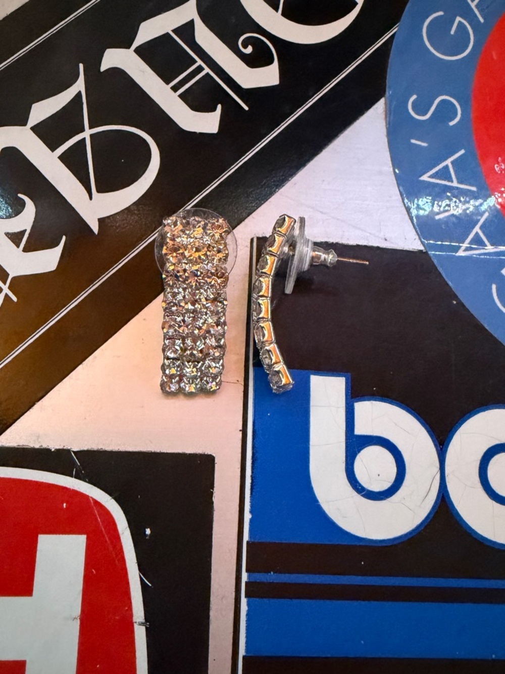 Silver rectangular earrings filled with shiny stones.